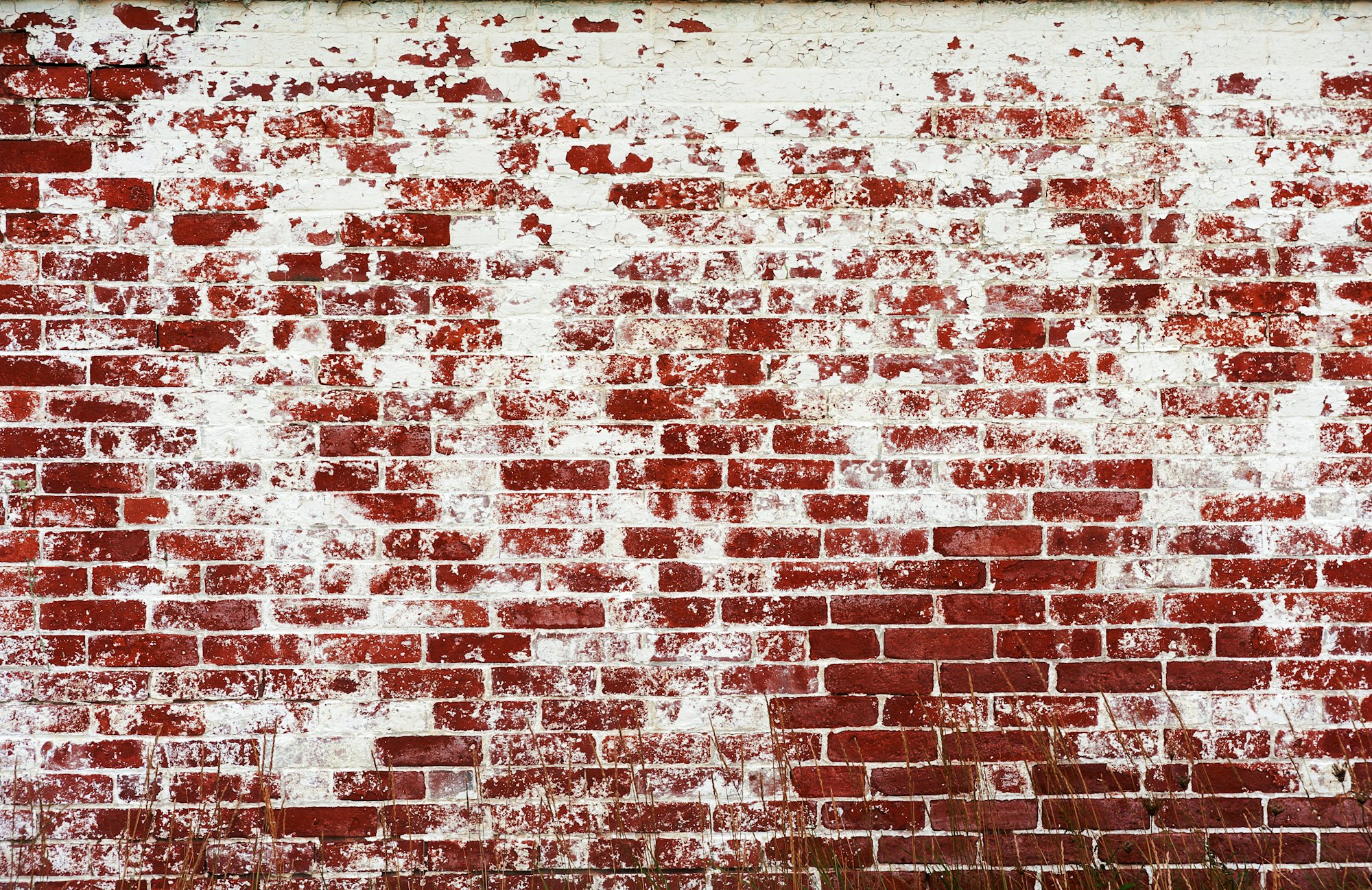 Abstract background Old damaged peeled brick wall painted red